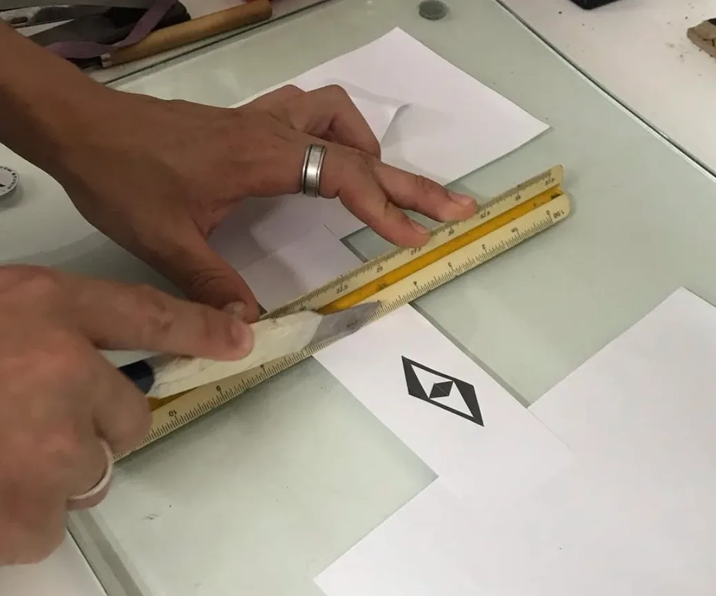 Mesa de trabalho com canetas, régua e impressões