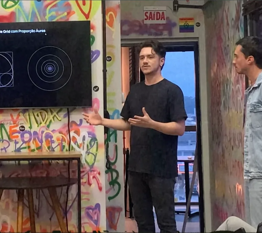 Pedro apresentando em frente a um painel grafitado